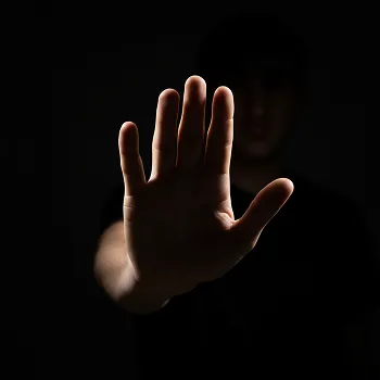 Close-up of an outstretched hand with fingers spread against a dark background.